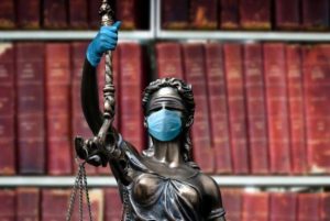 Statue of Lady Justice wearing mask and gloves for COVID-19 virus