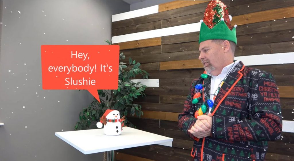 Man dressed in Christmas Jacket with Talking snowman named Slushie