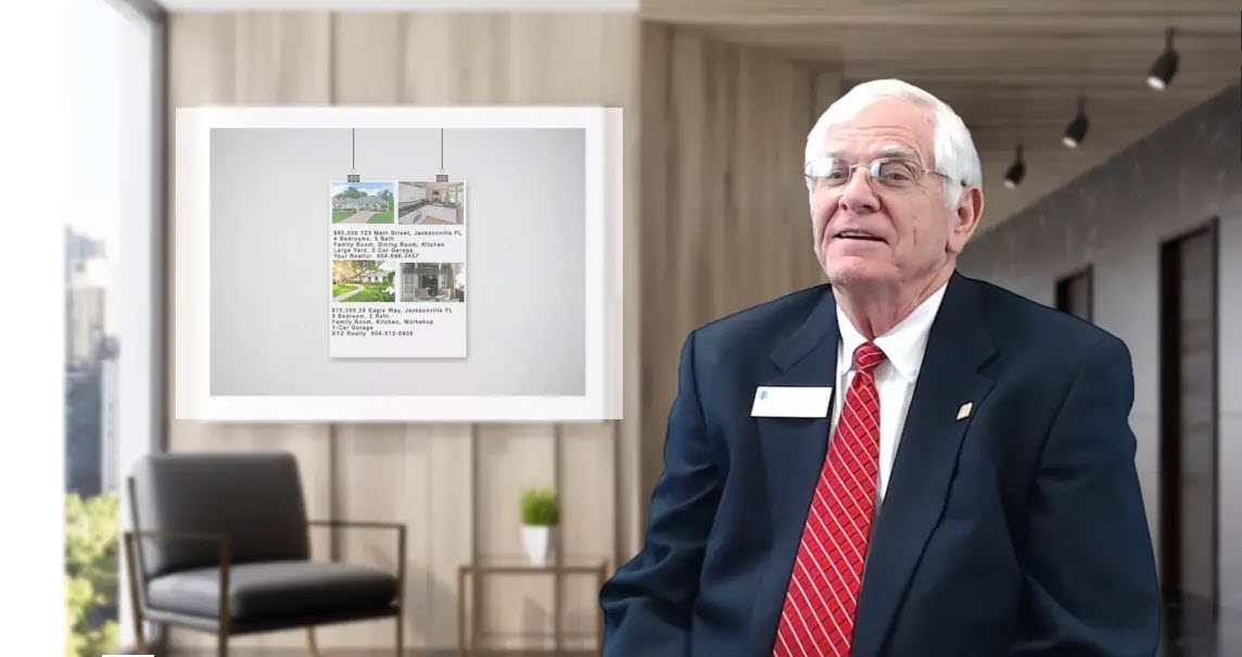 Older businessman in an office environment with a whiteboard in the background displaying pictures of homes