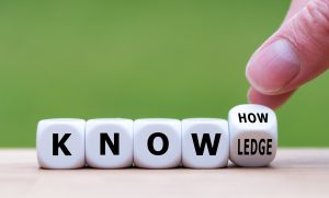 To have know-how or to have knowledge. Hand turns a dice and changes the word "know-how" to "knowledge".