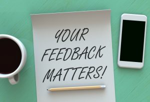 Your Feedback Matters, message on paper, smart phone and coffee on table