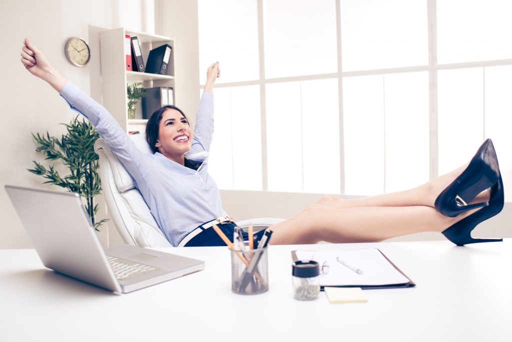 Successful Business Woman in Office with Feet on Desk